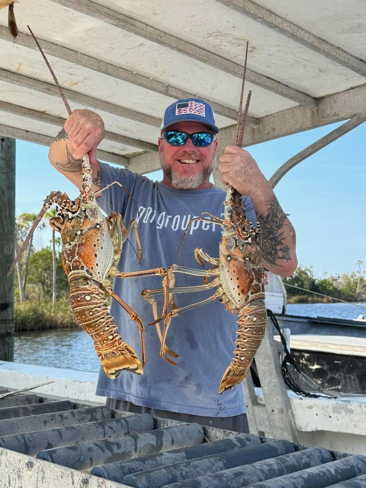 Adam on the dock holding two Florida Keys lobsters